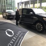 Chauffeur in mask with luxury SUV